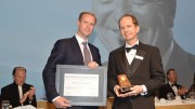 Doug Donnelly (right), Canadian Mining Hall of Fame director and publisher of The Northern Miner, presenting to Gavin McOuat, son of inductee Jack McOuat. Credit: Canadian Mining Hall of Fame