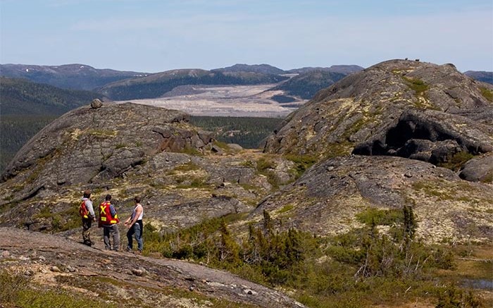Three geologists look toward the Voisey's Bay open pit mine. Photo by Joshua Duggan (CC 2.0).